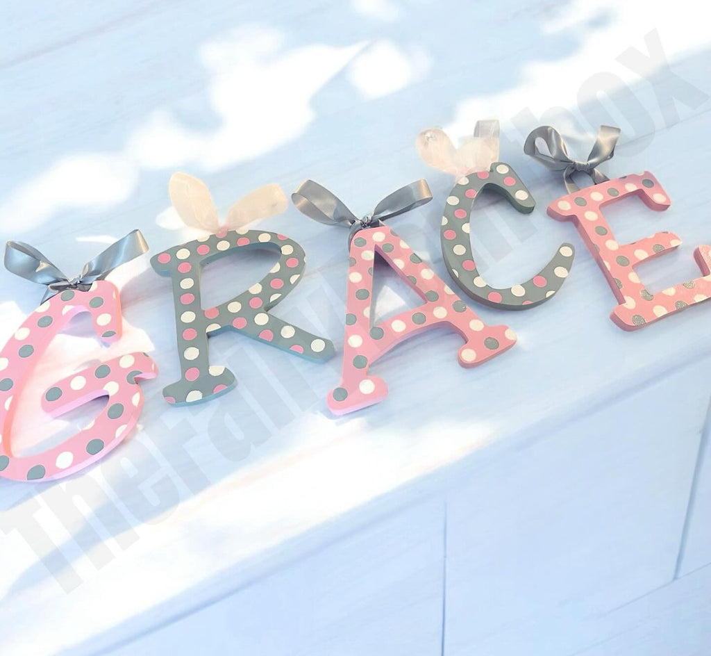 Decorative letters with polka dot design spelling 'GRACE' on a light blue background