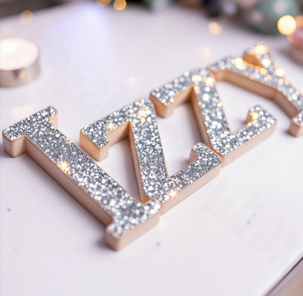 Decorative letters with glittery silver accents on a light background