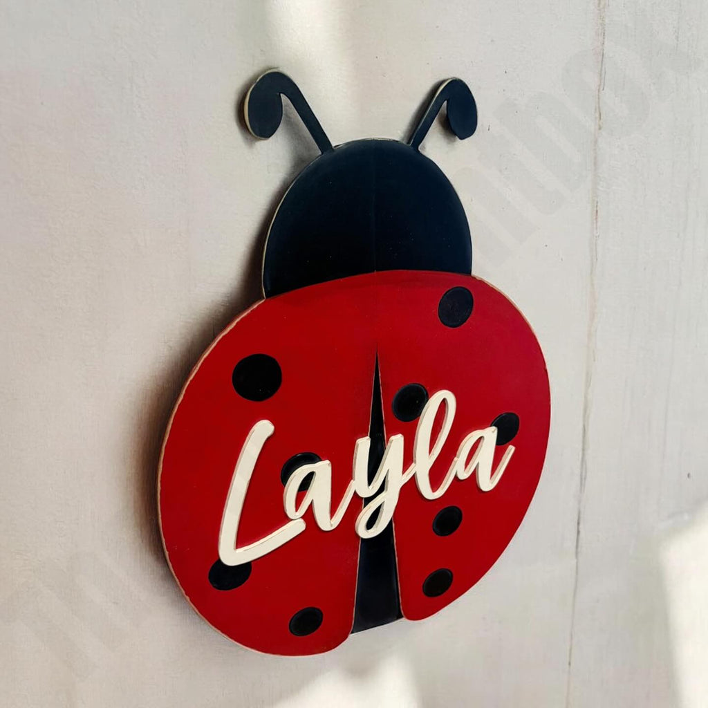 Red ladybug-shaped clock with 'Layla' on a white background