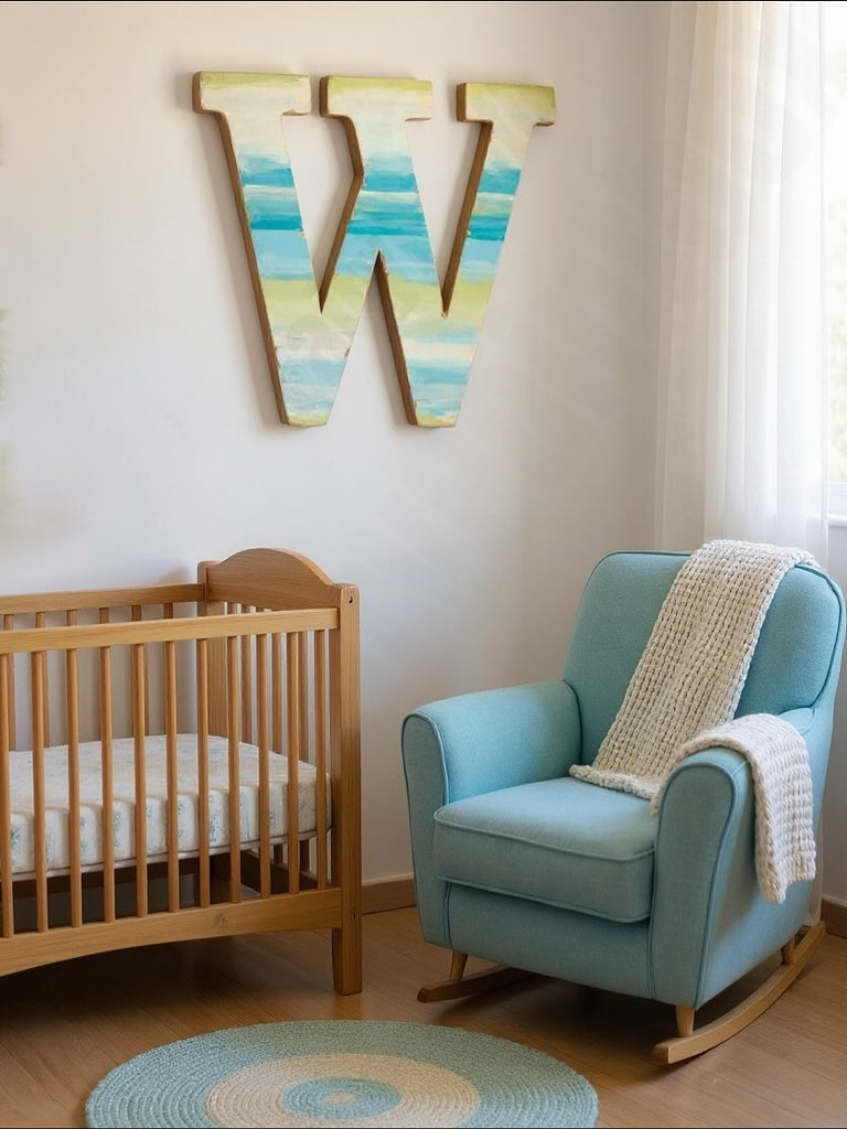 Nursery room with wooden crib, blue armchair, and colorful 'W' wall decoration.