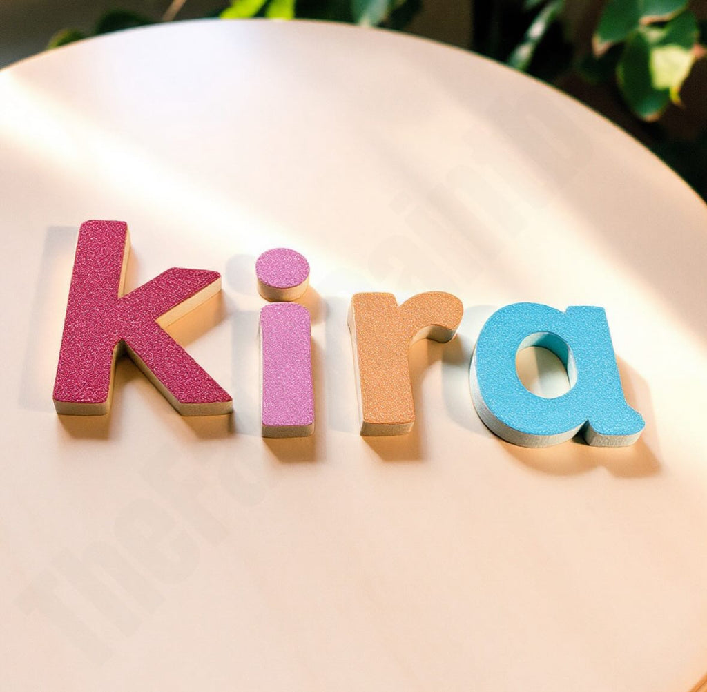 glitter wood letters that sit on a table in a baby's room